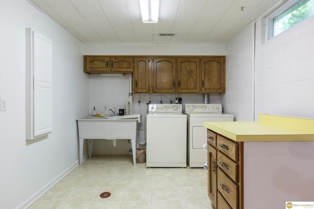 10919 N 69th St, Omaha, NE 68152 - laundry room with cabinet space, washer and clothes dryer, concrete block wall, and light tile patterned floors