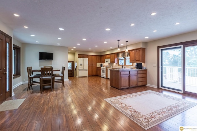 10919 N 69th St, Omaha, NE 68152 - kitchen with white appliances, brown cabinetry, healthy amount of natural light, recessed lighting, and baseboards