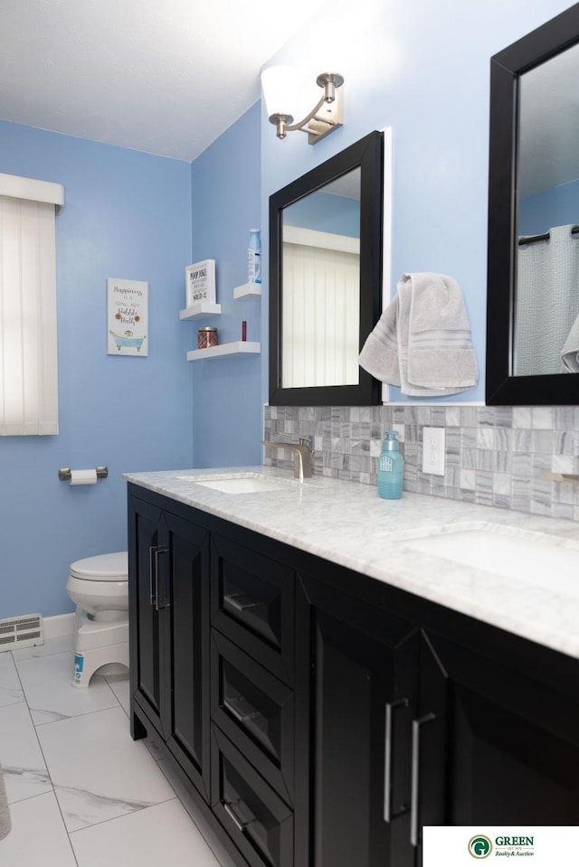 6 N Circle Dr, York, NE 68467 - full bath with decorative backsplash, toilet, double vanity, and marble look tile flooring