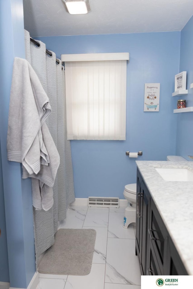 6 N Circle Dr, York, NE 68467 - bathroom featuring marble look tiles, toilet, vanity, a shower with curtain, and baseboards