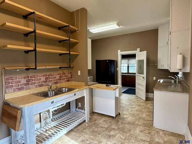 339 S Columbia Ave, Seward, NE 68434 - kitchen featuring freestanding refrigerator, open shelves, white cabinetry, and a sink