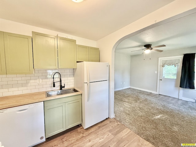 518 N 18th St, Nebraska City, NE 68410 - kitchen featuring white appliances, a sink, a ceiling fan, decorative backsplash, and light wood-type flooring