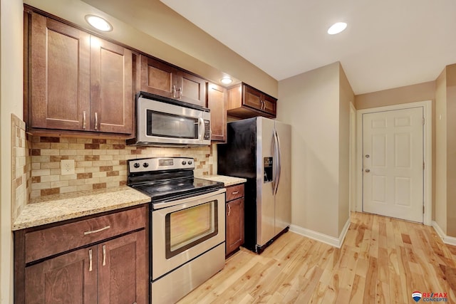 6609 Shenandoah Ct, Lincoln, NE 68510 - kitchen with stainless steel appliances, baseboards, light wood-style flooring, backsplash, and recessed lighting