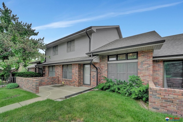 6609 Shenandoah Ct, Lincoln, NE 68510 - rear view of house with a patio area, a lawn, a shingled roof, and brick siding