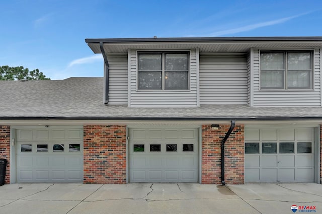 6609 Shenandoah Ct, Lincoln, NE 68510 - view of home's exterior with brick siding, an attached garage, roof with shingles, and driveway