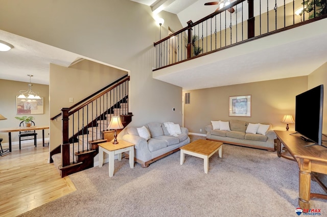 6609 Shenandoah Ct, Lincoln, NE 68510 - carpeted living area with a high ceiling, stairs, a chandelier, wood finished floors, and baseboards
