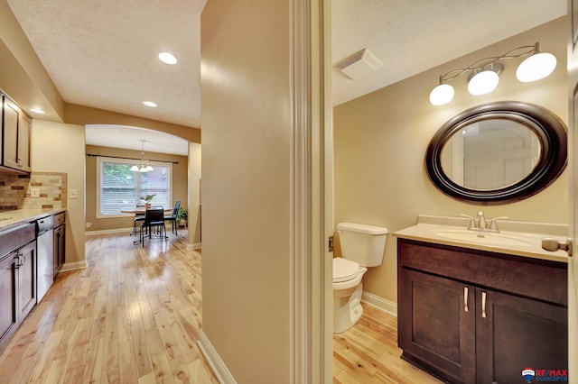 6609 Shenandoah Ct, Lincoln, NE 68510 - bathroom with hardwood / wood-style flooring, baseboards, vanity, toilet, and recessed lighting