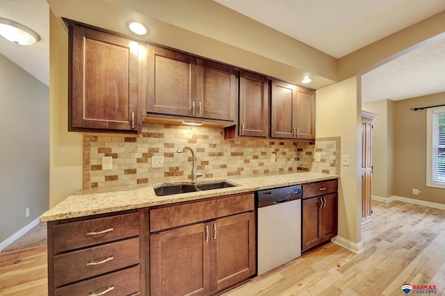 6609 Shenandoah Ct, Lincoln, NE 68510 - kitchen with dishwasher, a sink, light wood-style floors, and light stone countertops