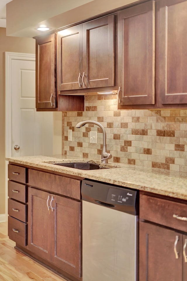 6609 Shenandoah Ct, Lincoln, NE 68510 - kitchen with dishwasher, a sink, backsplash, light wood-type flooring, and light stone countertops