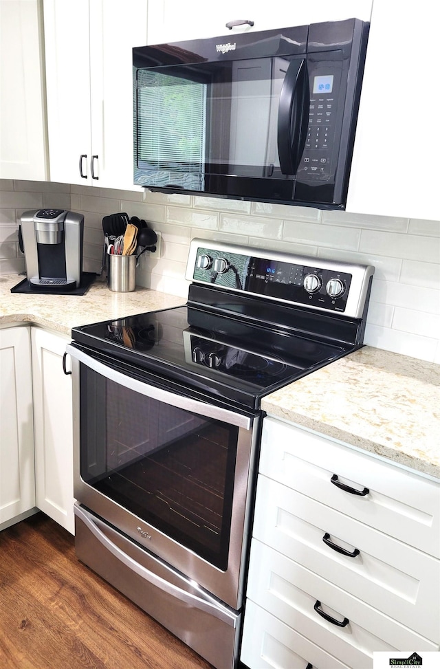 5201 Danbury Ct, Lincoln, NE 68512 - kitchen with stainless steel range with electric cooktop, black microwave, tasteful backsplash, white cabinets, and light stone counters