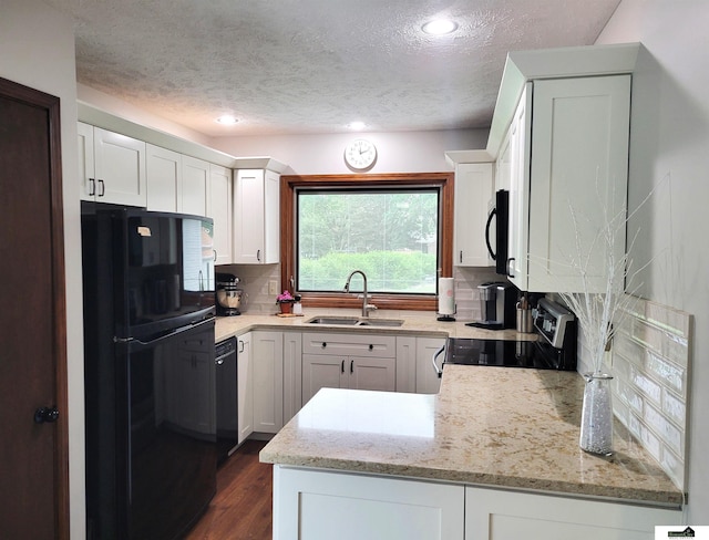 5201 Danbury Ct, Lincoln, NE 68512 - kitchen featuring a sink, black appliances, light stone countertops, white cabinetry, and a textured ceiling