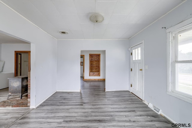 165 Monroe St, Bennet, NE 68317 - empty room with wood finished floors, baseboards, and a wood stove