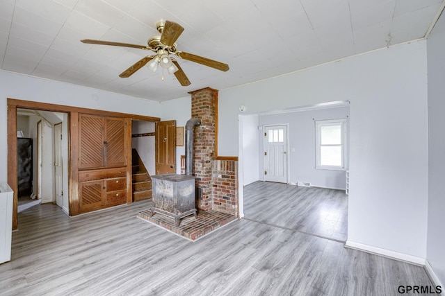 165 Monroe St, Bennet, NE 68317 - unfurnished living room featuring a wood stove, wood finished floors, and ceiling fan