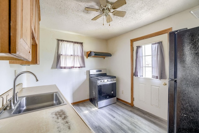 165 Monroe St, Bennet, NE 68317 - kitchen featuring gas stove, a sink, freestanding refrigerator, plenty of natural light, and a textured ceiling