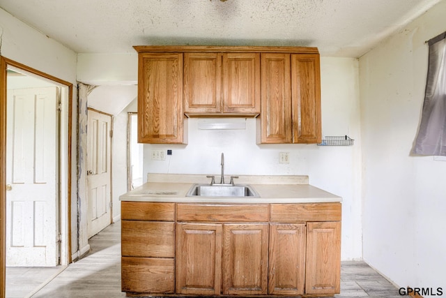 165 Monroe St, Bennet, NE 68317 - kitchen with a sink, light wood finished floors, light countertops, and brown cabinets