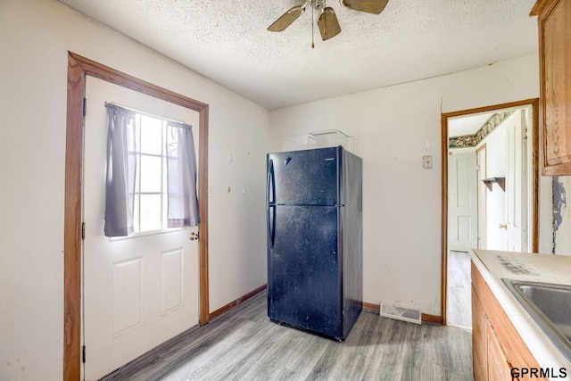 165 Monroe St, Bennet, NE 68317 - kitchen with freestanding refrigerator, light wood-type flooring, ceiling fan, a textured ceiling, and a sink
