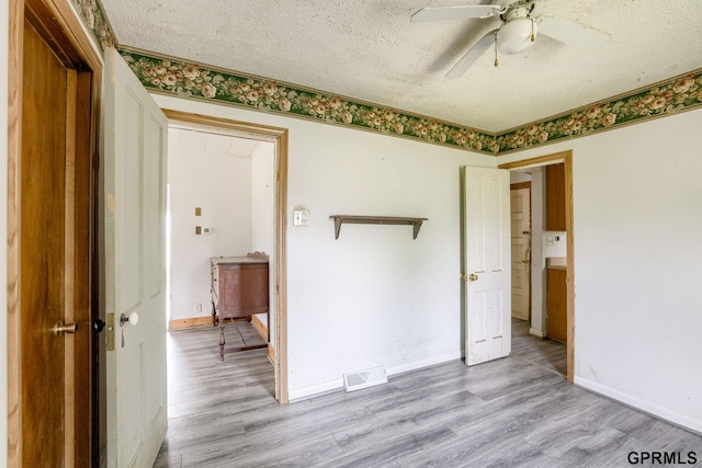 165 Monroe St, Bennet, NE 68317 - empty room featuring light wood-style flooring, ceiling fan, a textured ceiling, and baseboards
