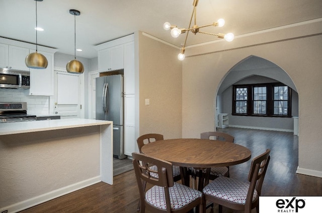 131 S 39th St Unit 6, Omaha, NE 68131 - dining space featuring arched walkways, dark wood finished floors, a chandelier, and baseboards