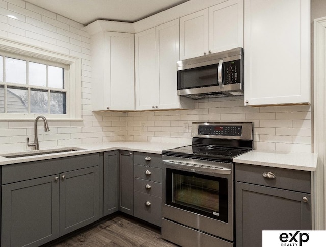 131 S 39th St Unit 6, Omaha, NE 68131 - kitchen with stainless steel appliances, a sink, gray cabinetry, backsplash, and light countertops