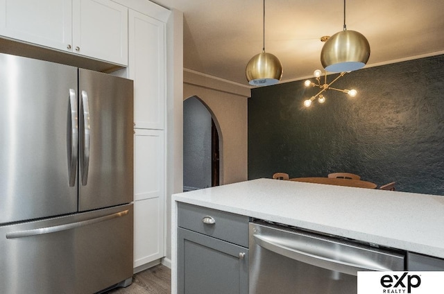 131 S 39th St Unit 6, Omaha, NE 68131 - kitchen with appliances with stainless steel finishes, arched walkways, light countertops, white cabinetry, and crown molding