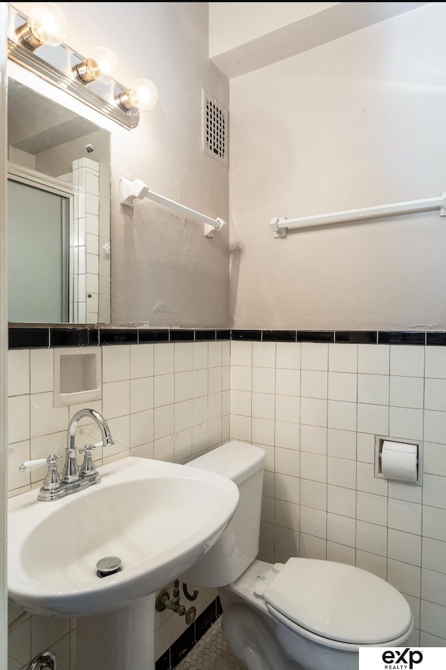 131 S 39th St Unit 6, Omaha, NE 68131 - bathroom with tile walls, toilet, a shower stall, and a sink