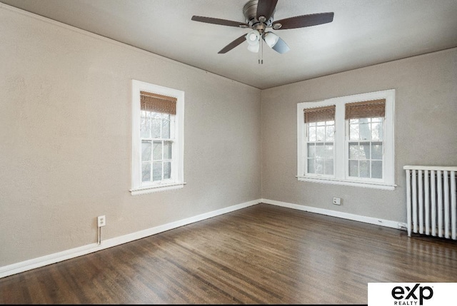 131 S 39th St Unit 6, Omaha, NE 68131 - spare room featuring radiator heating unit, dark wood-style floors, baseboards, and a ceiling fan
