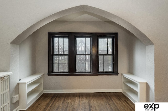 131 S 39th St Unit 6, Omaha, NE 68131 - additional living space featuring dark wood-style flooring, baseboards, a textured wall, and arched walkways