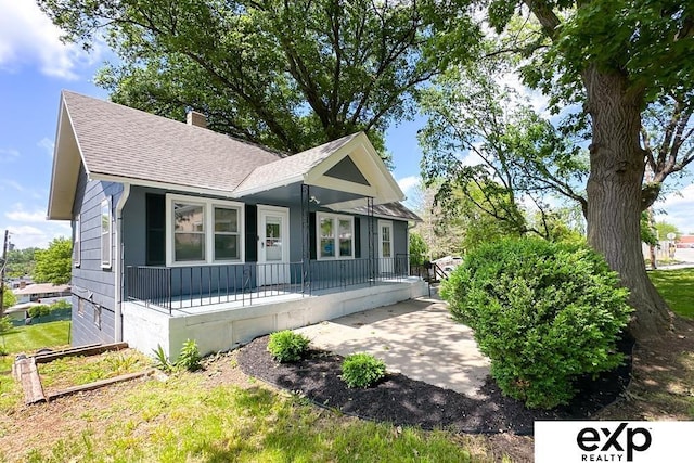 2626 N 67th St, Omaha, NE 68104 - view of front facade featuring a porch, roof with shingles, and a chimney