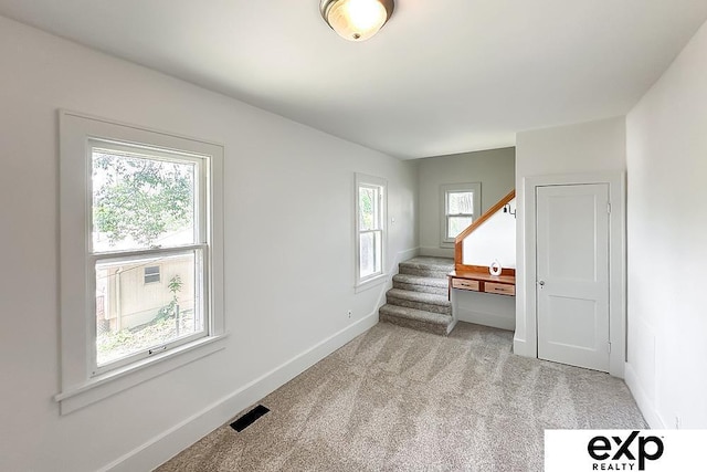 2626 N 67th St, Omaha, NE 68104 - spare room with light colored carpet, baseboards, and stairway