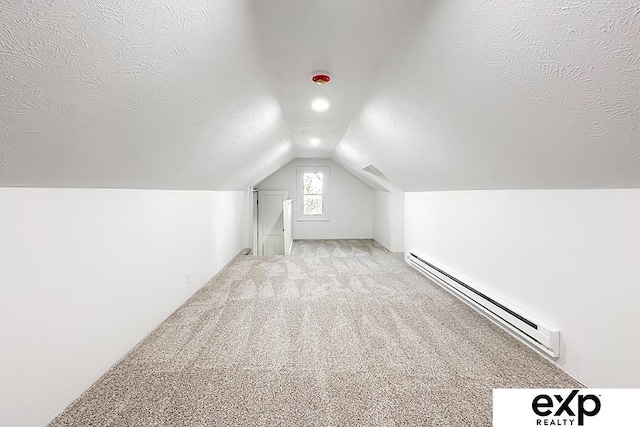 2626 N 67th St, Omaha, NE 68104 - additional living space with a baseboard heating unit, lofted ceiling, carpet flooring, and a textured ceiling