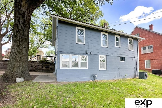 2626 N 67th St, Omaha, NE 68104 - rear view of house with central AC unit, a lawn, and a patio area