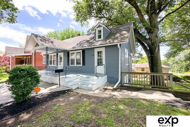 2626 N 67th St, Omaha, NE 68104 - view of front of property featuring covered porch, a chimney, and a shingled roof