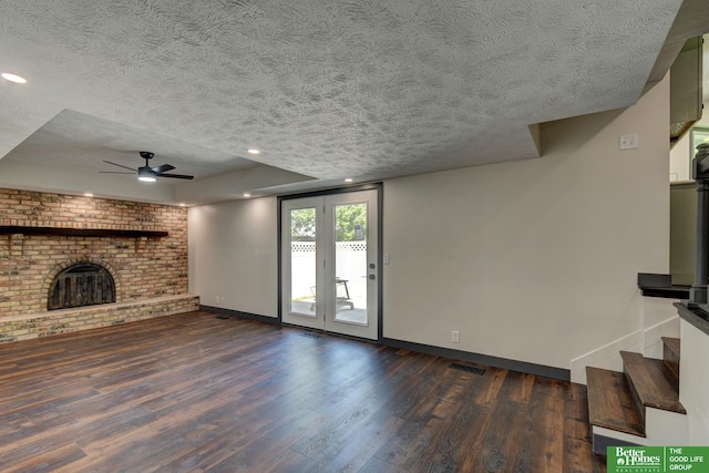 11680 Meredith Ave, Omaha, NE 68164 - unfurnished living room featuring a brick fireplace, a textured ceiling, dark wood-style floors, baseboards, and a ceiling fan