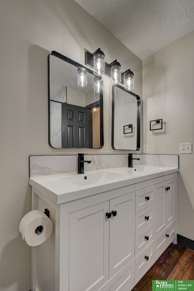 11680 Meredith Ave, Omaha, NE 68164 - full bath with wood finished floors, double vanity, a textured ceiling, and baseboards