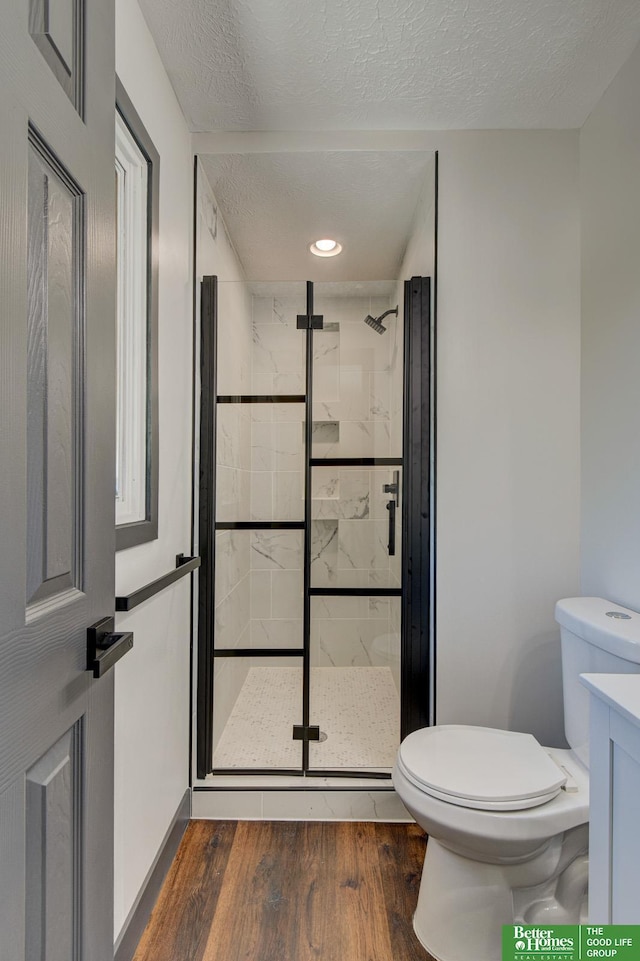 11680 Meredith Ave, Omaha, NE 68164 - bathroom with toilet, a shower stall, wood finished floors, and a textured ceiling