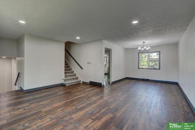 11680 Meredith Ave, Omaha, NE 68164 - unfurnished living room featuring a chandelier, dark wood finished floors, baseboards, recessed lighting, and a textured ceiling