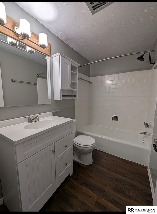 2515 3rd Street Plz, Omaha, NE 68108 - full bathroom featuring wood finished floors, vanity, a textured ceiling, shower / washtub combination, and toilet
