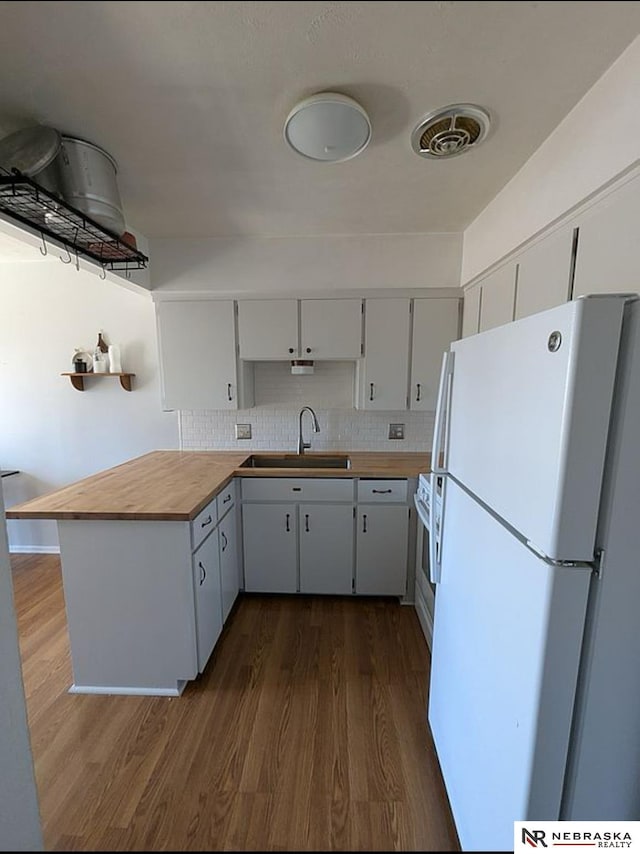 2515 3rd Street Plz, Omaha, NE 68108 - kitchen with freestanding refrigerator, a sink, dark wood-type flooring, wood counters, and decorative backsplash