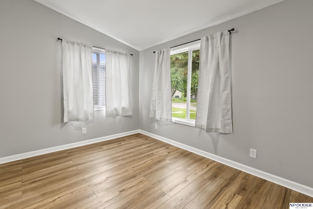 4656 Redick Ave, Omaha, NE 68152 - empty room with vaulted ceiling, baseboards, and wood finished floors