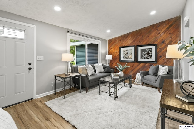 4656 Redick Ave, Omaha, NE 68152 - living area with wooden walls, healthy amount of natural light, recessed lighting, wood finished floors, and baseboards