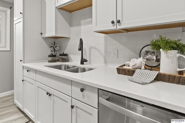 4656 Redick Ave, Omaha, NE 68152 - kitchen with a sink, dishwasher, decorative backsplash, light countertops, and white cabinetry