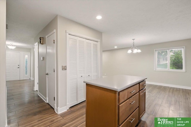 5143 S 126th Plz Unit 22, Omaha, NE 68137 - kitchen with wood finished floors, a kitchen island, plenty of natural light, baseboards, and recessed lighting