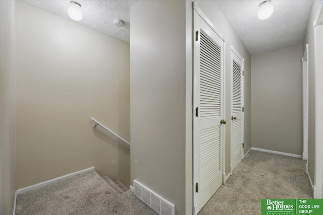 5143 S 126th Plz Unit 22, Omaha, NE 68137 - hall with carpet floors, an upstairs landing, a textured ceiling, and baseboards