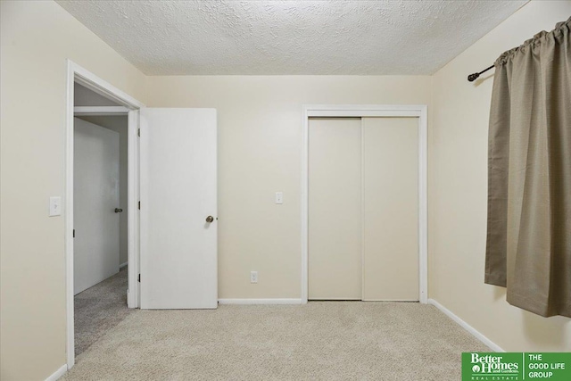 5143 S 126th Plz Unit 22, Omaha, NE 68137 - unfurnished bedroom featuring carpet flooring, a textured ceiling, a closet, and baseboards