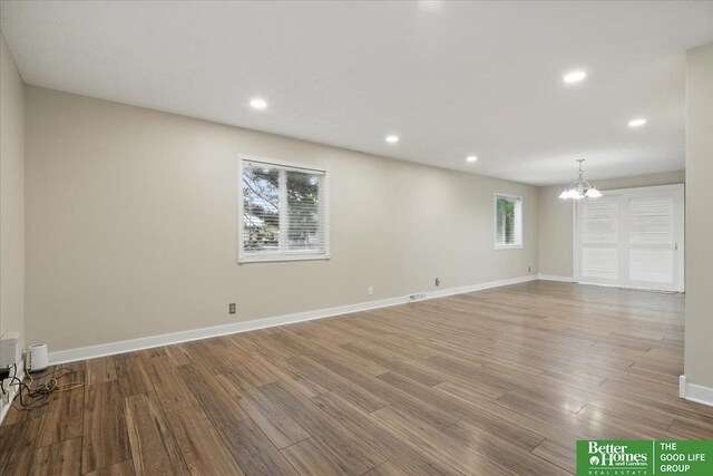 5143 S 126th Plz Unit 22, Omaha, NE 68137 - unfurnished living room with a chandelier, wood finished floors, baseboards, and recessed lighting