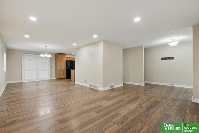 5143 S 126th Plz Unit 22, Omaha, NE 68137 - unfurnished living room with a chandelier, wood finished floors, baseboards, and recessed lighting