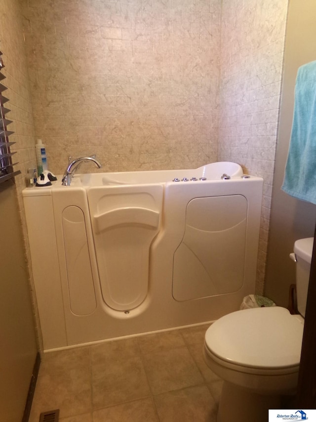 1304 S 4th Ave, Beatrice, NE 68310 - bathroom with tile patterned floors, a bath, and toilet