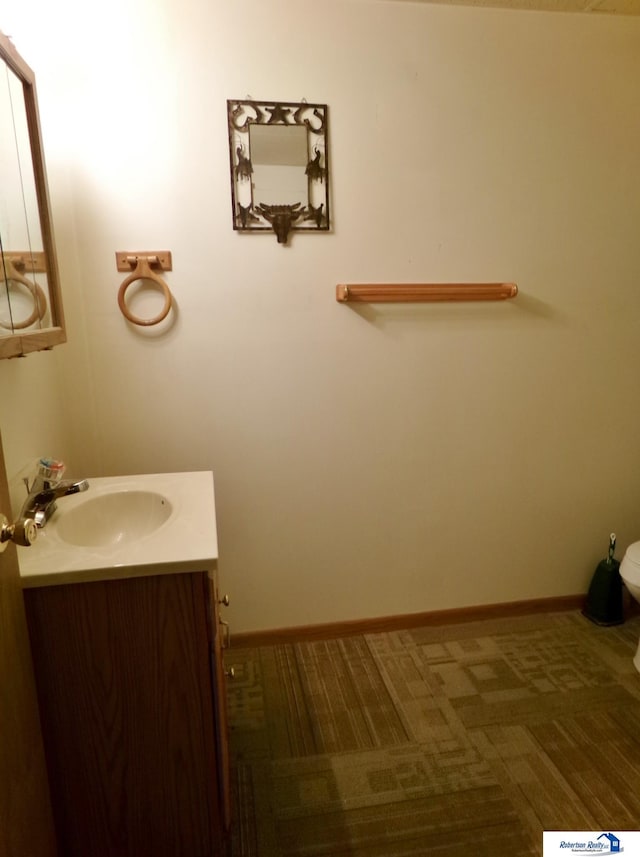 1304 S 4th Ave, Beatrice, NE 68310 - half bathroom featuring vanity, toilet, and baseboards
