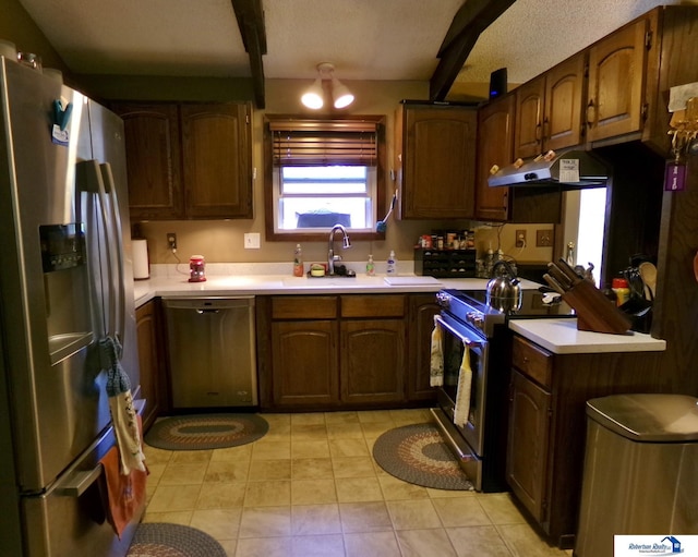 1304 S 4th Ave, Beatrice, NE 68310 - kitchen featuring appliances with stainless steel finishes, light countertops, under cabinet range hood, a sink, and beamed ceiling