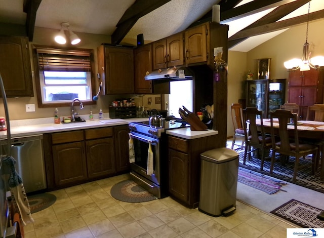 1304 S 4th Ave, Beatrice, NE 68310 - kitchen with stainless steel appliances, light countertops, a chandelier, and under cabinet range hood